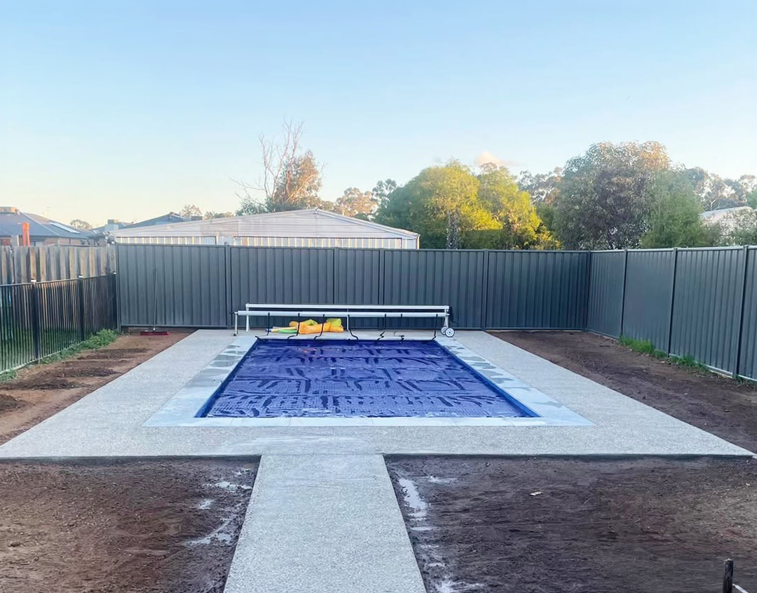 Pool area after landscaping with finished paving, pathway and garden beds